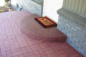 Exposed aggregate porch surrounded by brick pavers